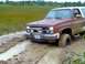 1989 Ford Bronco - This SUV is stuck in a muddy field, with its front tire deep in the mire.
