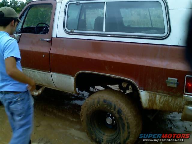 Muddy off-road SUV with a person standing next to it