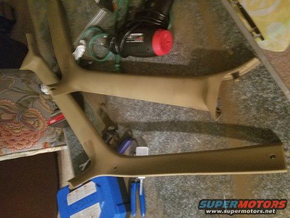 Tan interior trim pieces on floor with tools