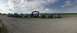 1989 Ford Bronco - A group of off-road vehicles are lined up on a dirt road under a cloudy sky.