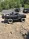 1989 Ford Bronco - Modified 1989 Ford Bronco on a trail with other off-road vehicles in the background.