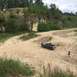1989 Ford Bronco - 1989 Ford Bronco navigating a dirt path in a rocky, wooded area.