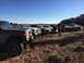 1989 Ford Bronco - A group of trucks are parked in a grassy field under a clear blue sky.