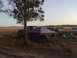 1989 Ford Bronco - Multiple SUVs are parked at a campsite with a tent and chairs set up in a grassy field.