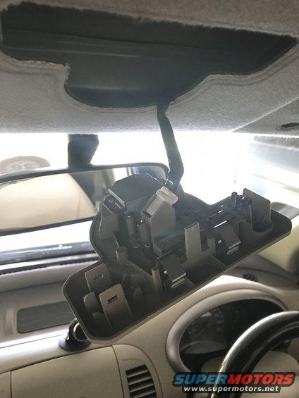 Interior part removed from car headliner, showing wiring and clips