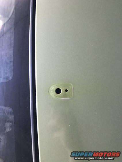 Green car door handle mounting point with two holes