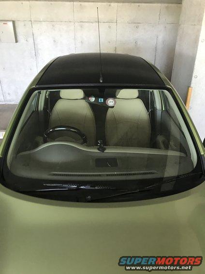 Interior of light green car with black roof, tan seats, and dashboard