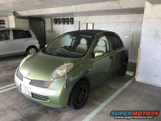 Green 2003 Nissan Micra parked in a garage, with another silver car visible behind it