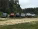 1989 Ford Bronco - A lineup of SUVs, including a green 1989 Ford Bronco, parked outdoors on a cloudy day.