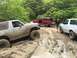 1989 Ford Bronco - Three Ford Broncos navigate a muddy trail, with one vehicle deeply mired in the mire.