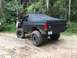 1989 Ford Bronco - This modified Ford Bronco is shown off-road on a muddy path, with a second vehicle partially visible in the background.