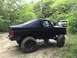 1989 Ford Bronco - Modified 1989 Ford Bronco navigating a muddy off-road trail with a soft top.