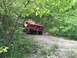 1989 Ford Bronco - Red 1989 Ford Bronco navigates a wooded off-road path.