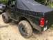 1989 Ford Bronco - This 1989 Ford Bronco is heavily mud-splattered, indicating it has been used for off-roading. Another vehicle is partially visible to the l…