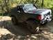 1989 Ford Bronco - This modified Ford Bronco navigates a challenging muddy path, its off-road capabilities.