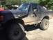 1989 Ford Bronco - Muddy 1989 Ford Bronco with off-road modifications, parked outdoors.