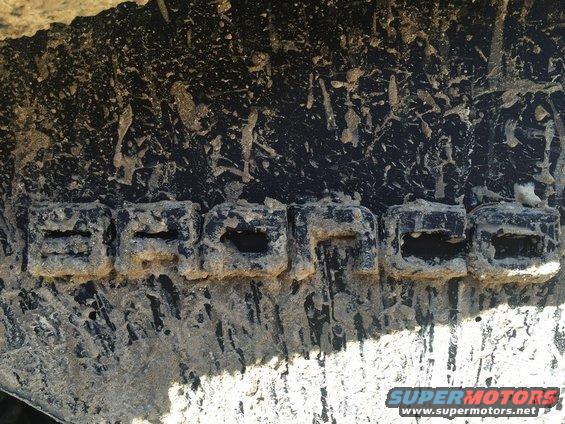 Close-up of a tire tread with mud on it. The word BRONCO is visible in the tread