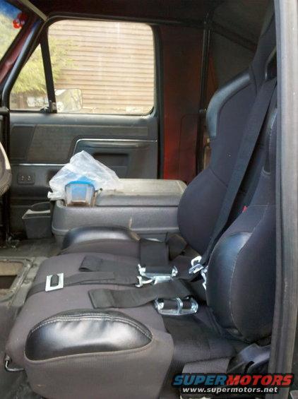 Interior view of racing seats and center console with a plastic container on top