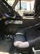 1989 Ford Bronco - The interior of a vehicle features a Ford steering wheel and a custom center console with multiple cup holders.