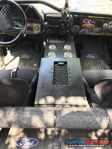 1989 Ford Bronco interior with custom center console, Ford floor mats, and stickers on the dashboard