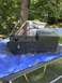 1989 Ford Bronco - A black center console, possibly from a vehicle, is displayed outdoors on a blue tarp.