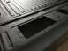 1989 Ford Bronco - Close-up of a textured black truck bed liner, showing ribbed patterns and recessed areas.