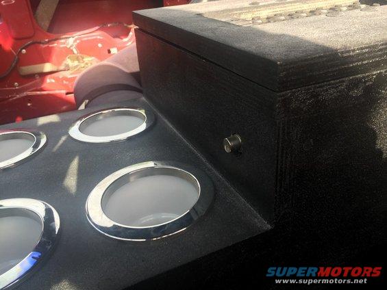 Custom center console with four gauge pods and a black storage box. Red interior visible behind