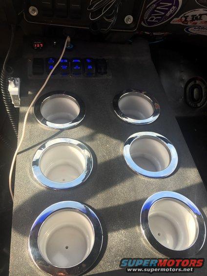 Custom cup holder console with six chrome-trimmed holders, blue-lit switches, and a digital display