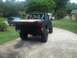 1989 Ford Bronco - This modified black Ford Bronco, likely from the late 1980s, is parked in a driveway with another SUV in the background.