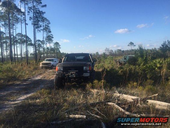 1989 Ford Bronco parked off-road with two other SUVs in background