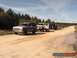 1989 Ford Bronco - A convoy of SUVs, including a 1987 Ford Bronco, travels down a dusty dirt road lined with trees.