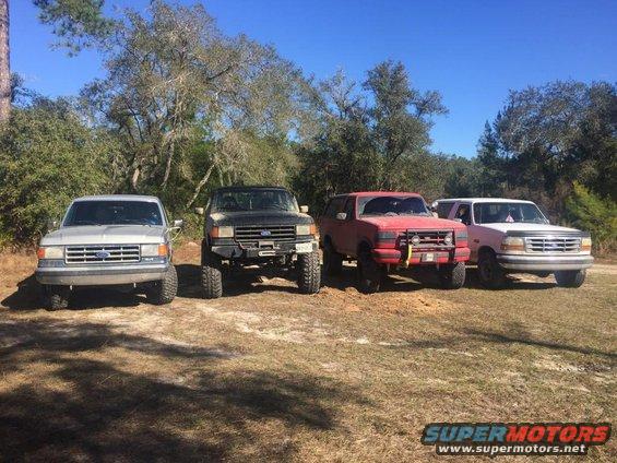 four Ford Broncos and F-150s parked outside