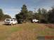 1989 Ford Bronco - A group of four SUVs, including a white 1989 Ford Bronco, are parked in a grassy area on a sunny day.