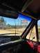 1989 Ford Bronco - Interior view of a vehicle parked near a U.S. Navy Bombing Range, with numerous stickers on the dashboard.