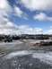 1989 Ford Bronco - A variety of trucks and trailers are parked in an outdoor lot under a cloudy sky.