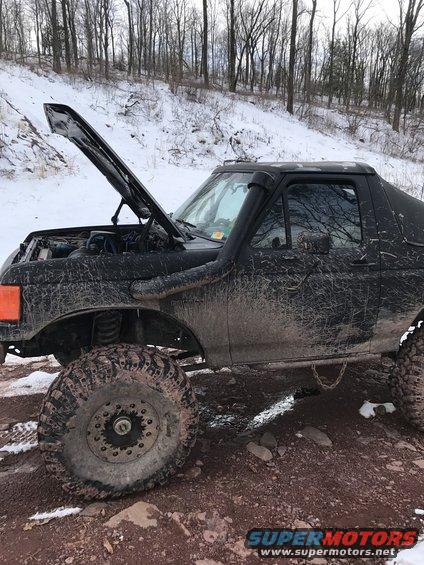 Black 1989 Ford Bronco with hood open, snorkel, and large off-road tires