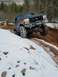 1989 Ford Bronco - A lifted Ford Bronco navigates a challenging off-road course with snow and mud.