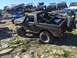 1989 Ford Bronco - Multiple off-road vehicles are parked on a rocky hill under a clear blue sky.