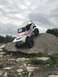 1989 Ford Bronco - This modified Ford Bronco is navigating a challenging rock obstacle on an off-road course.
