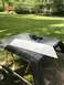 1989 Ford Bronco - A vehicle hardtop is placed on sawhorses outdoors, with a metal panel and tools on its surface.