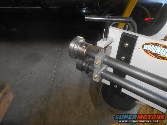 sheet metal roller with 'WOODWARD' logo, part of a car in background