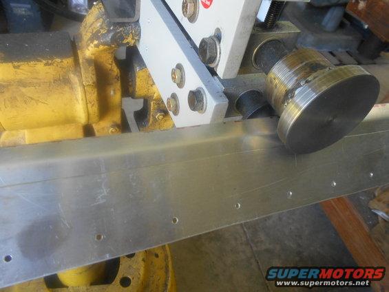 Metal fabrication equipment with a roller pressing on a metal sheet