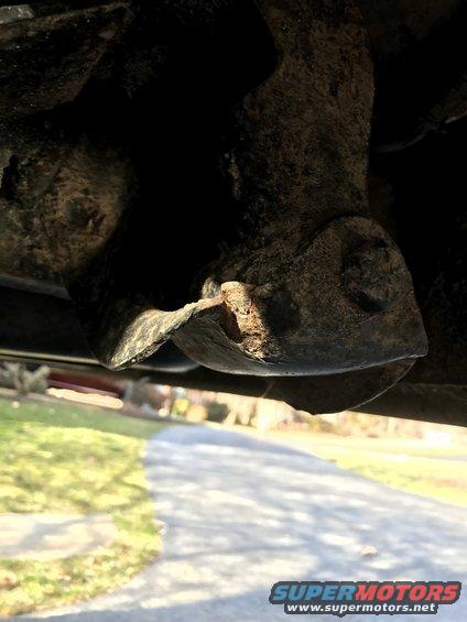 close-up of rusty metal suspension component under a vehicle