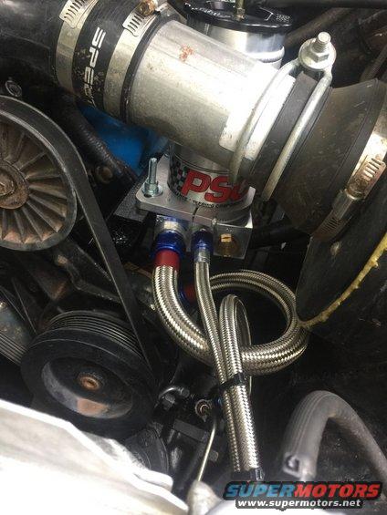 Engine bay showing power steering pump with braided hoses and Spectre intake tube