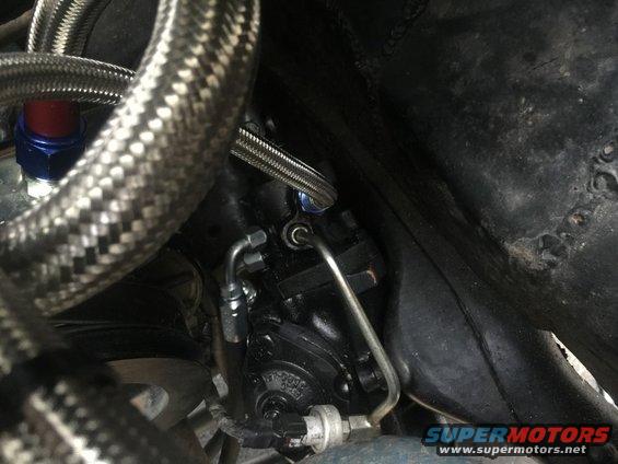 Power steering pump with braided hoses and metal lines, close-up view