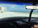 1989 Ford Bronco - Driving a Ford Bronco on the beach, with the ocean and buildings visible through the windshield.