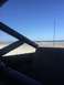 1989 Ford Bronco - Looking out from the interior of a vehicle towards a beach scene on a sunny day.