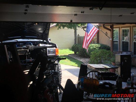 Black SUV front with hood open, American flag visible