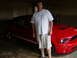 2007 Ford Mustang - A man stands beside a red 2007 Ford Mustang GT 500 in a garage.