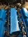 1989 Ford Bronco - Close-up of a blue engine intake manifold with fuel injectors and blue tape covering part of it.